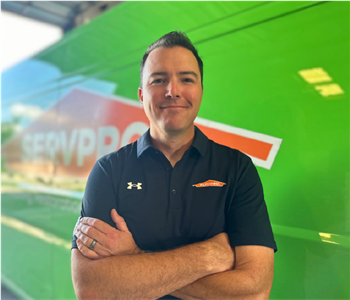 Servpro General Manager and owner stands in front of Green Vehicle