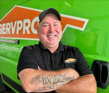 Project Manager Standing in front of Servpro Fleet